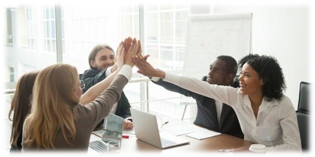 employees sitting at a conference table high fiving